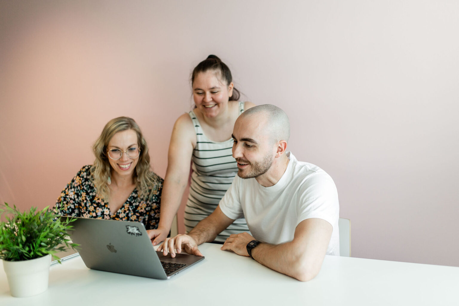 Three people are working together with laptop.